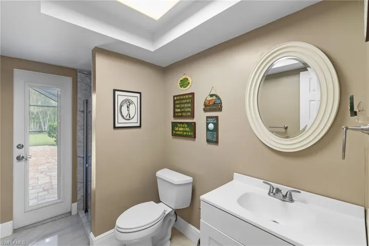 Bathroom featuring baseboards, vanity, and toilet