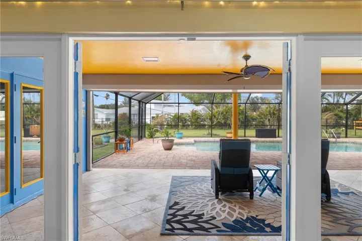 Doorway to outside with ceiling fan, tile patterned flooring, and a sunroom