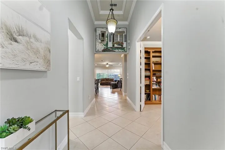 VOLUME CEILINGS AND LARGE ENTRY WITH BATHROOM AND BEDROOM TO LEFT AND LIBRARY/DEN SEEN IN THIS PHOTO ON RIGHT. HALLWAY ON LEFT GOES TO ANOTHER BEDROOM, BATHROOM, AND LAUNDRY - TO GARAGE