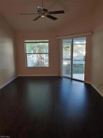 Empty room with dark wood-type flooring and a ceiling fan