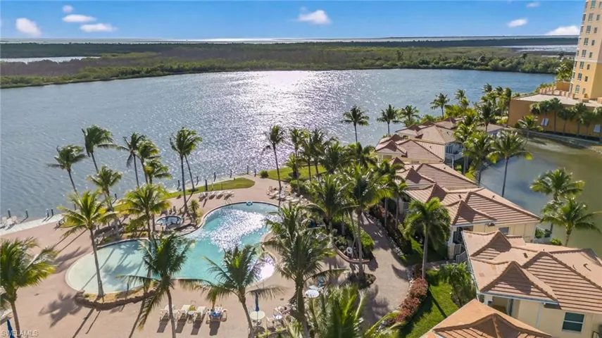Aerial view of a pool area and a large body of water