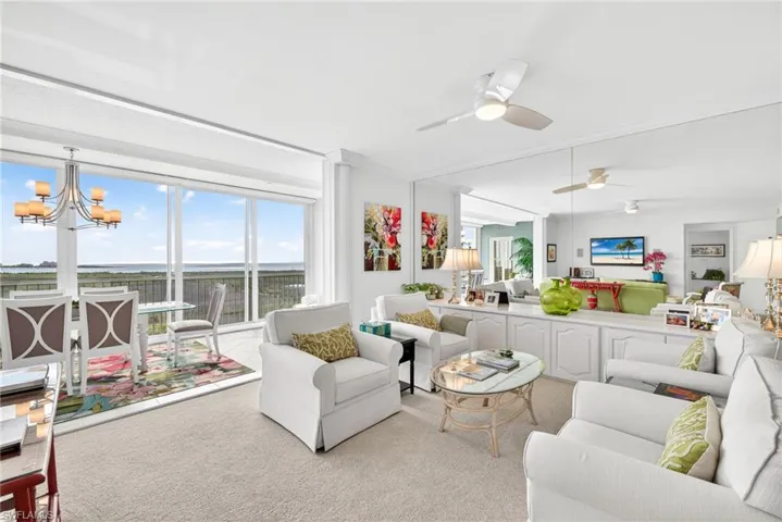 Carpeted living room with a chandelier and a ceiling fan