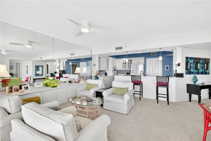 Living room featuring light carpet and a ceiling fan