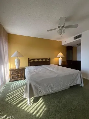 Carpeted bedroom featuring a ceiling fan