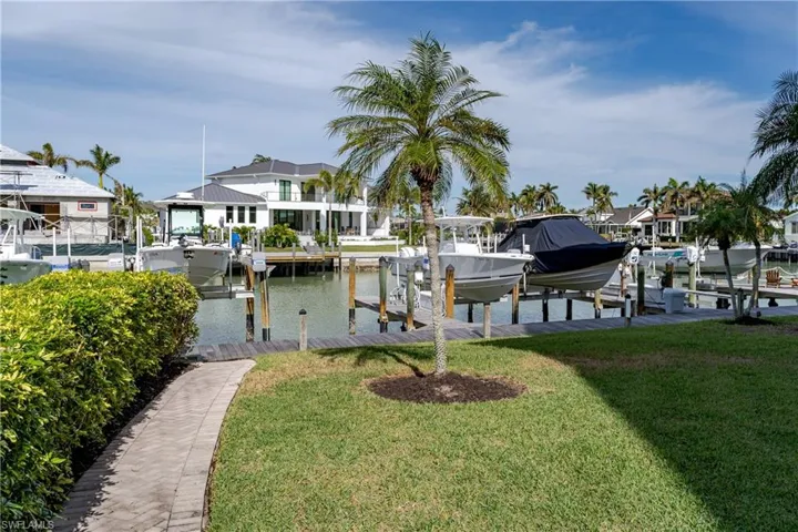 Dock area with a water view and a yard