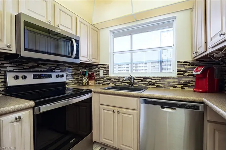Kitchen featuring appliances with stainless steel finishes, sink, and tasteful backsplash