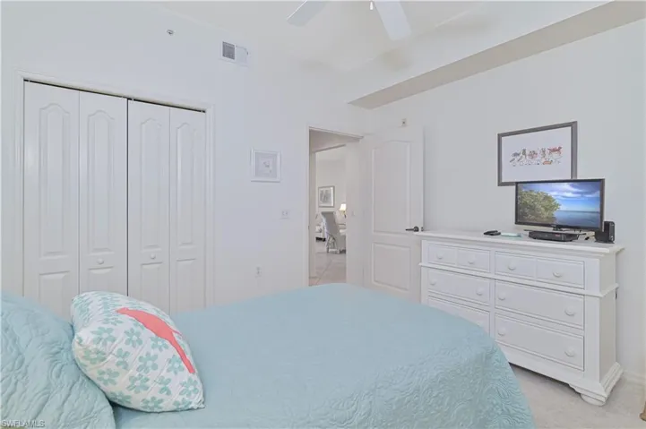 Bright bedroom featuring light wall tones, a ceiling fan, and white bi-fold closet doors
