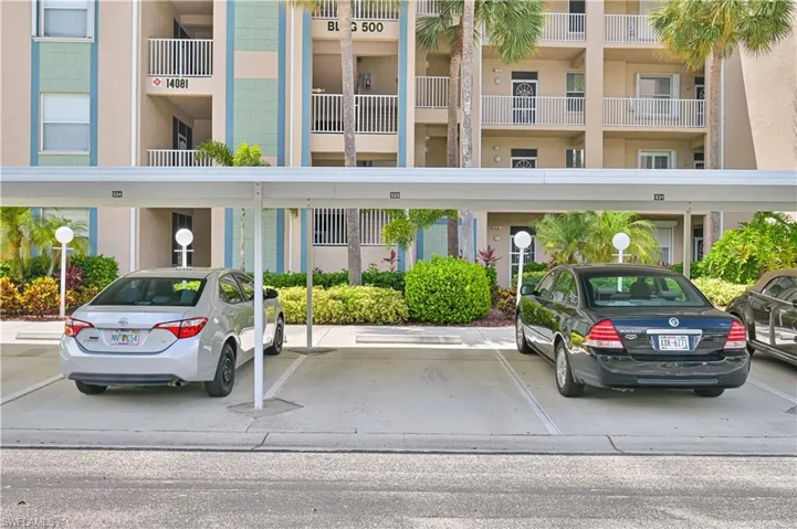 Covered parking structure with designated spaces, featuring overhead lighting and perimeter landscaping