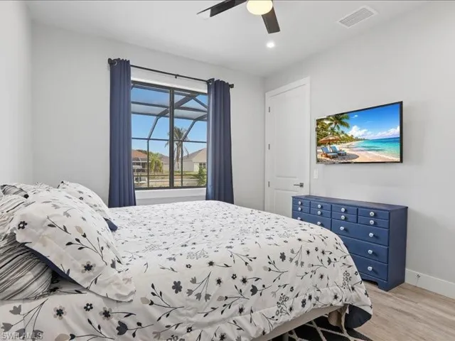 Bedroom with light wood finished floors, ceiling fan, and recessed lighting