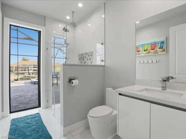 Bathroom featuring a stall shower, vanity, and recessed lighting