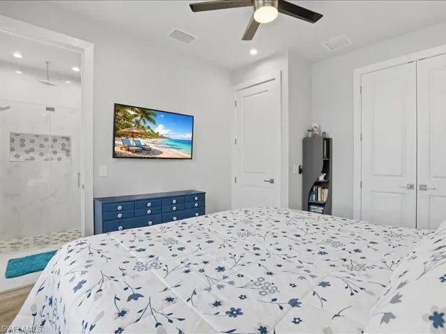 Bedroom with ensuite bathroom, ceiling fan, recessed lighting, and a closet