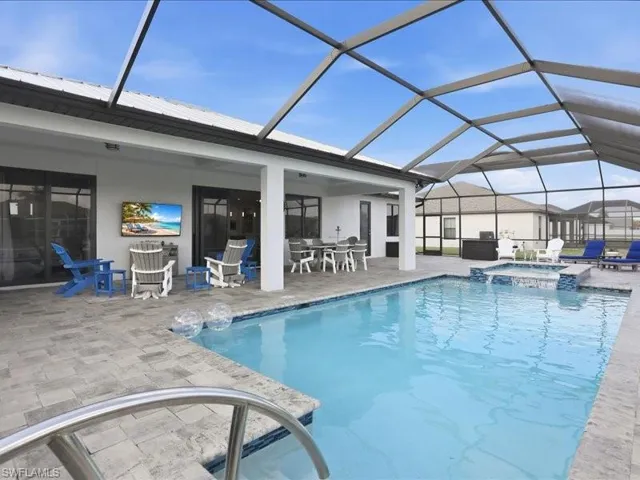 Integrated pool / hot tub featuring a sunroom, glass enclosure, outdoor dining area, and a patio