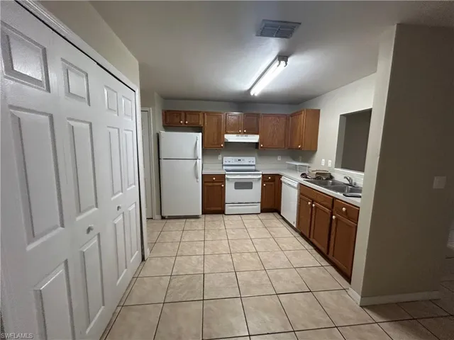 Laundry area featuring washer and clothes dryer and light tile patterned flooring
