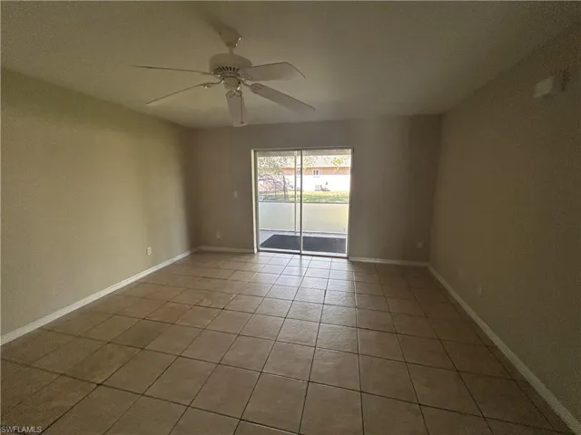 Empty room featuring light tile patterned floors and a ceiling fan