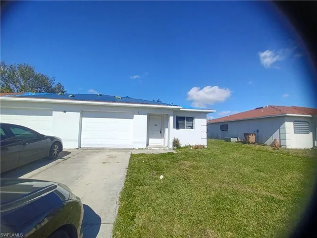Single story home with stucco siding, a front yard, driveway, and an attached garage