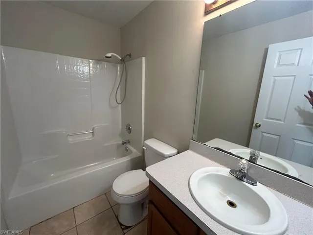 Full bath with vanity, shower / bath combination, and light tile patterned floors