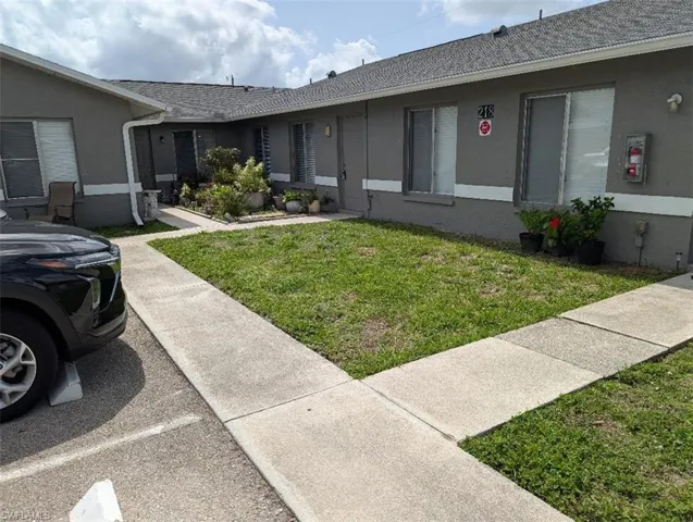 View of front of home featuring stucco siding and a front yard