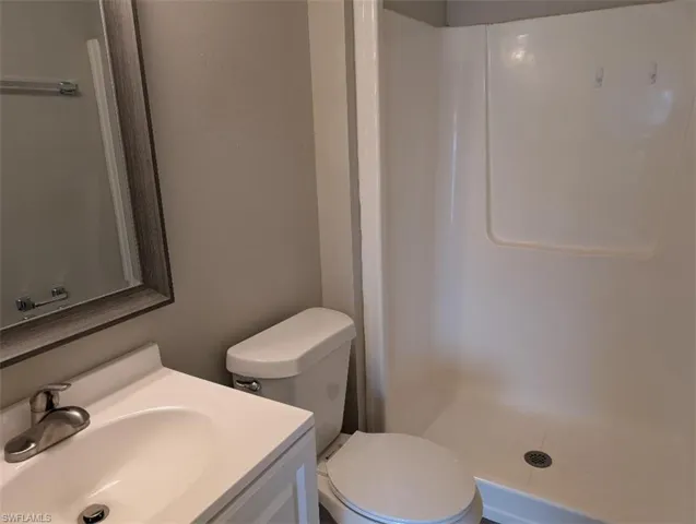 Full bath with a walk in shower, vanity, and toilet