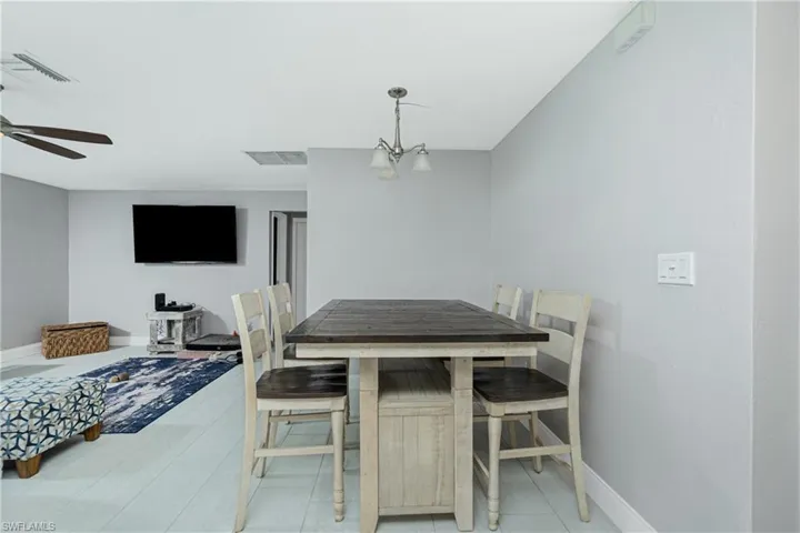 Dining area featuring ceiling fan with notable chandelier