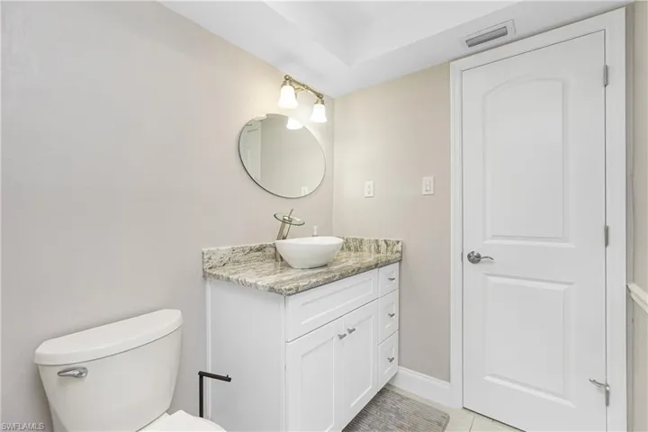 Bathroom with toilet, tile patterned floors, and vanity