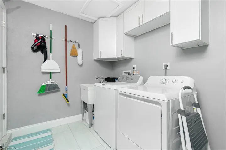 Laundry area with cabinets and washing machine and clothes dryer