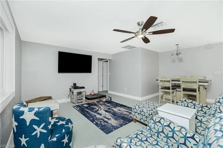 Living room featuring ceiling fan with notable chandelier