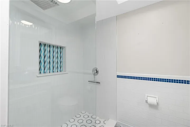 Bathroom with a tile shower and tile walls