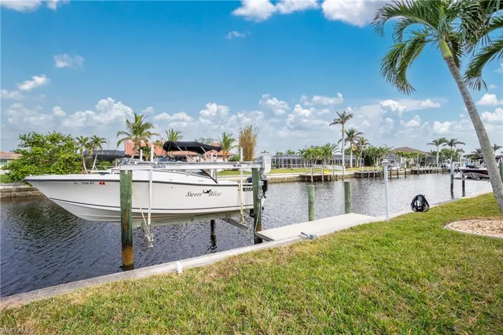 Dock area with a water view and a lawn