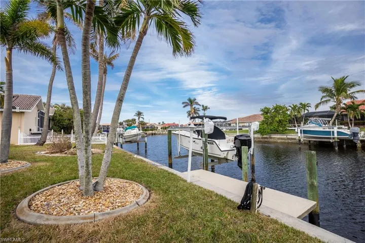 View of dock featuring a yard and a water view