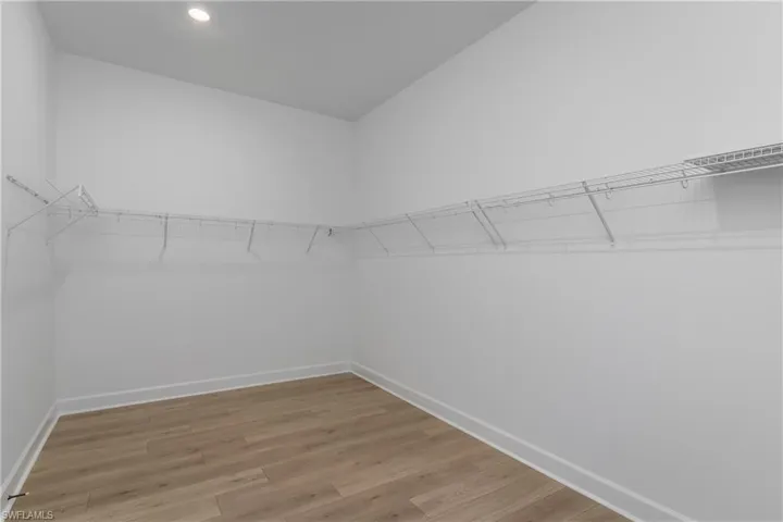 Spacious closet with light hardwood / wood-style floors