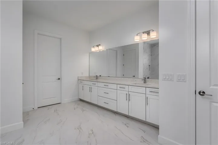 Bathroom with tile floors and dual bowl vanity