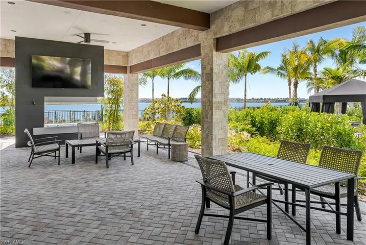 View of patio featuring an outdoor living space, ceiling fan, and a water view