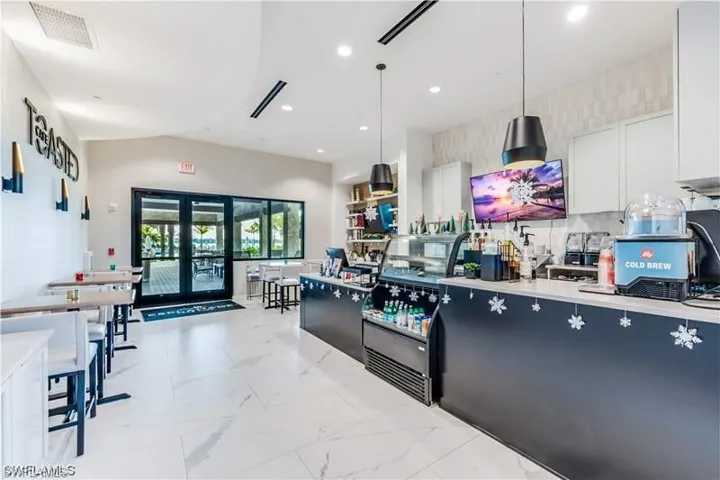 Kitchen featuring hanging light fixtures, white cabinetry, french doors, and light tile floors