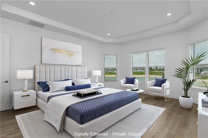 Bedroom featuring a tray ceiling and wood-type flooring
