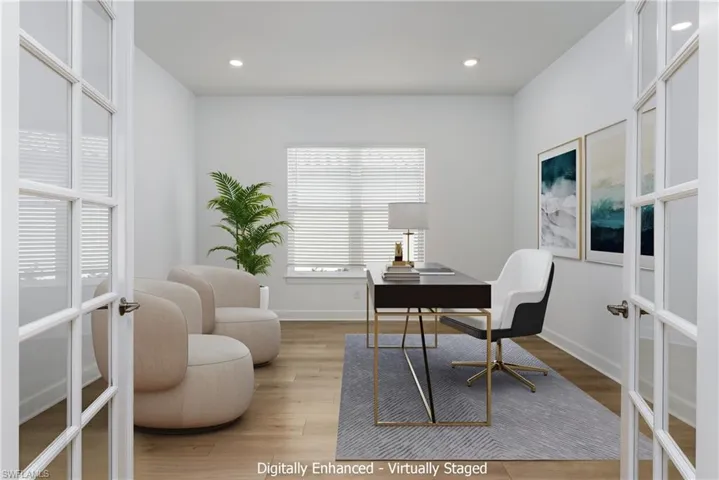 Office space with light hardwood / wood-style floors and french doors