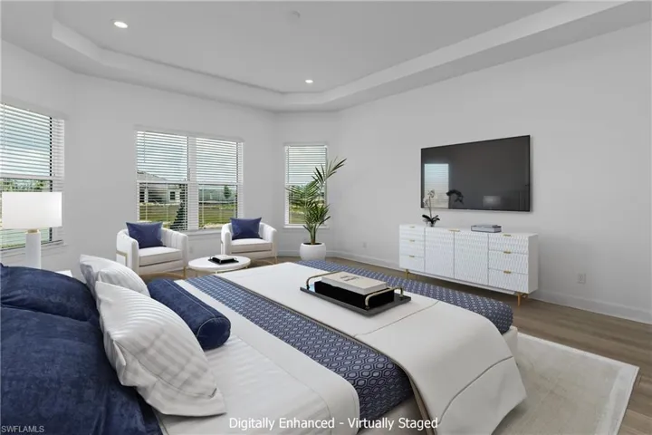 Bedroom with a tray ceiling and hardwood / wood-style flooring