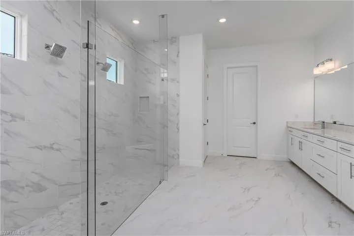 Bathroom featuring tile floors, a shower with shower door, and vanity