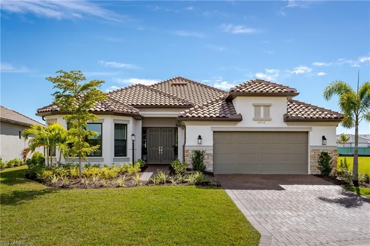 Mediterranean / spanish-style home featuring a garage and a front lawn
