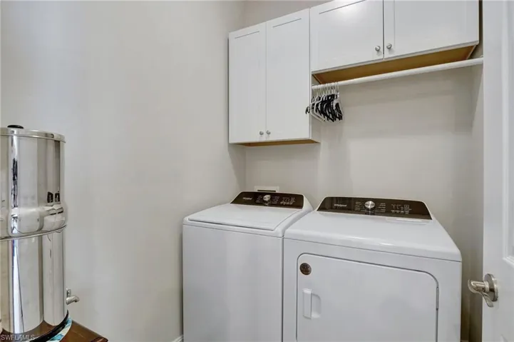 Washroom featuring washing machine and dryer and cabinets