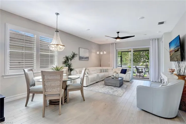 Dining room featuring ceiling fan with notable chandelier and light hardwood / wood-style flooring