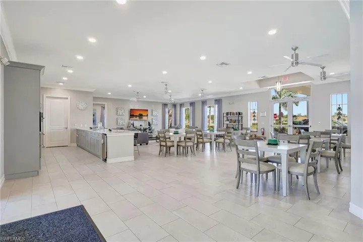 Dining space featuring ceiling fan, ornamental molding, and light tile patterned floors