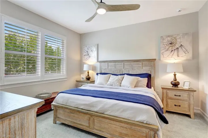 Carpeted bedroom featuring ceiling fan