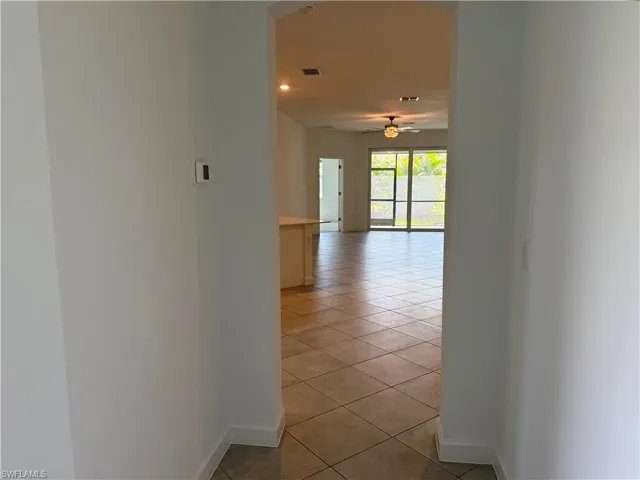 Expansive open-concept interior featuring tile flooring, a ceiling fan with integrated lighting, recessed lighting, and large sliding glass doors
