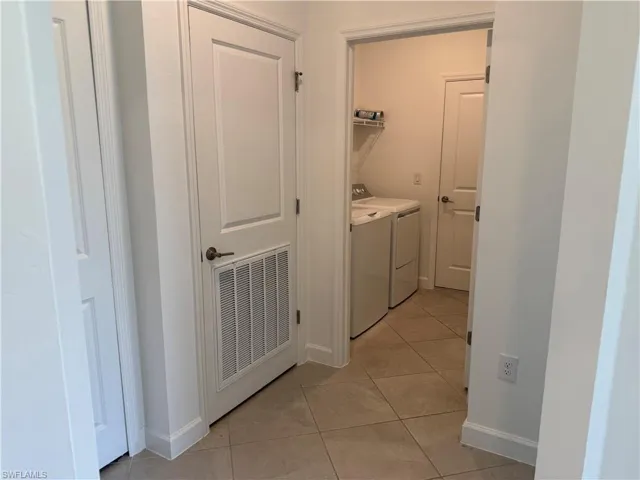 Utility area with tile flooring and white walls