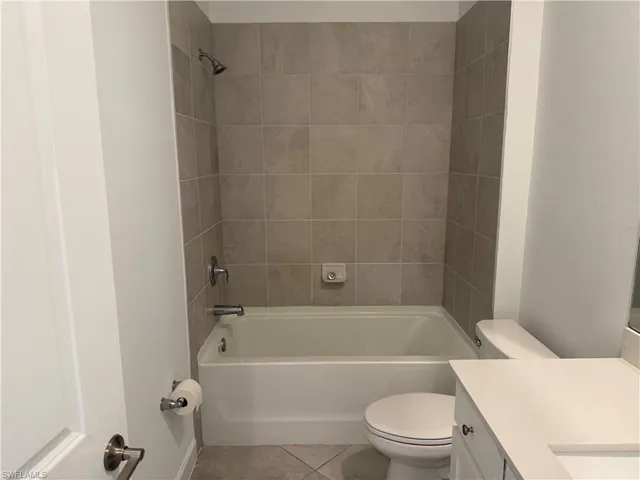 Bathroom featuring a white bathtub, ceramic tile surround, and brushed nickel fixtures
