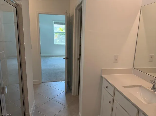 Bathroom vanity with white cabinetry, light-toned countertop, and undermount sink