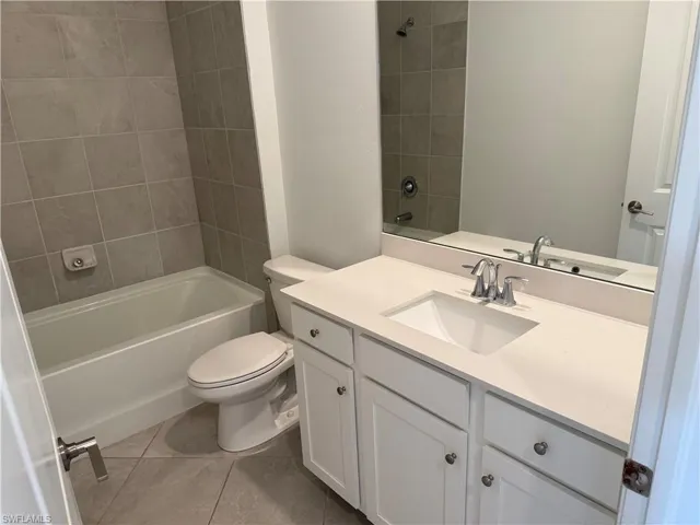 Bathroom featuring a white vanity with an undermount sink, a light-colored countertop, and chrome fixtures
