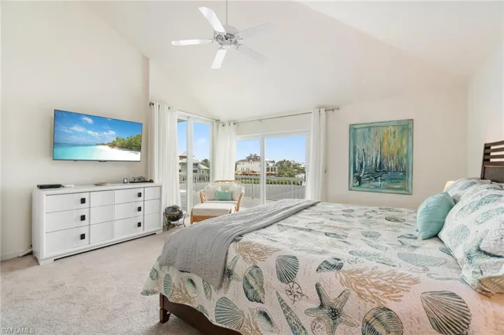 Bedroom featuring access to outside, light colored carpet, high vaulted ceiling, and ceiling fan