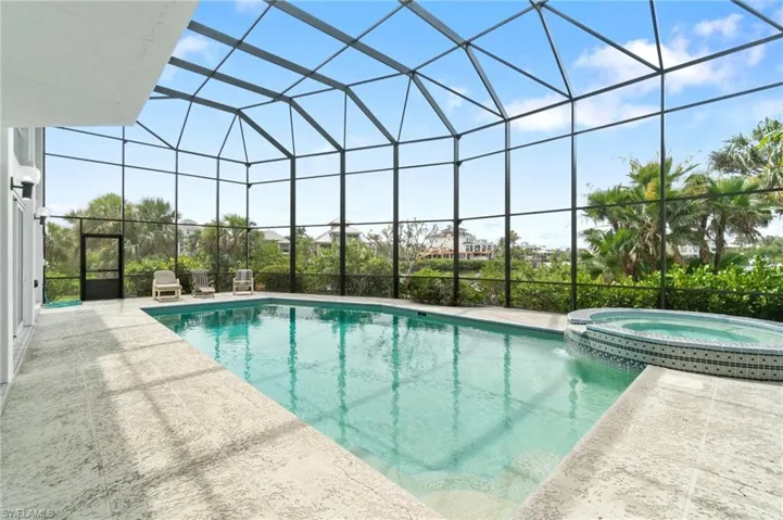 View of pool featuring a lanai, a patio area, and a pool with connected hot tub