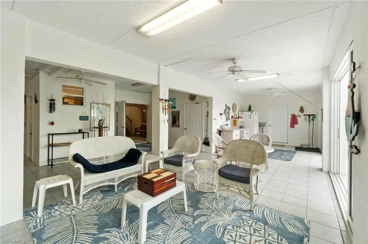 Living area featuring ceiling fan, light tile patterned floors, and a textured ceiling